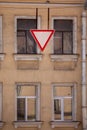 Give way Yield is a red and white triangle. Clear blue sky and the facade of the house behind the road sign. Royalty Free Stock Photo