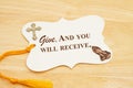 Give and you will receive message gift tag with yellow ribbon praying hands and cross Royalty Free Stock Photo