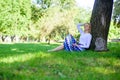 Give yourself break and enjoy leisure. Find peaceful place in park. Girl sit on grass lean on tree trunk relaxing in Royalty Free Stock Photo