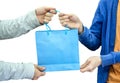 Giver hand holding blue paper bag with receiver Royalty Free Stock Photo