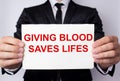 GIVING BLOOD ECONOMY OF LIFE inscription in red letters on a sheet of paper