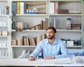 Giving the blueprints some thought. a handsome young male architect sitting in his office.