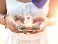 Giving heart, like symbol in speech bubble icon on social media on smart mobile phone in woman's hands using application. Royalty Free Stock Photo