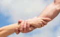 Giving a helping hand. Hands of man and woman on blue sky background. Lending a helping hand. Hands of man and woman Royalty Free Stock Photo