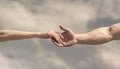 Giving a helping hand. Hands of man and woman on blue sky background. Lending a helping hand. Solidarity, compassion