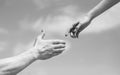 Giving a helping hand. Hands of man and woman on blue sky background. Lending a helping hand. Solidarity, compassion Royalty Free Stock Photo