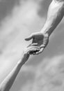 Giving a helping hand. Hands of man and woman on blue sky background. Lending a helping hand. Solidarity, compassion