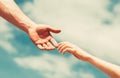 Giving a helping hand. Hands of man and woman reaching to each other, support. Hands of man and woman on blue sky Royalty Free Stock Photo