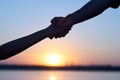 Giving a helping hand. Silhouette Two hands, man and woman, holding tight at sky sunset