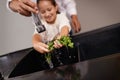 Giving her a helping hand. a little girl washing vegetables at the sink with the help of her grandfather. Royalty Free Stock Photo