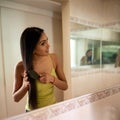 Giving Her Long, Gorgeous And Healthy Tresses Some Love. A Young Woman Brushing Her Hair In The Bathroom.