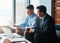 Giving legal advice online will double your money. two businessmen having a discussion while sitting by a laptop.