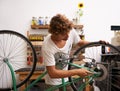 Giving the old bike a tuneup. a confident young bicycle repairman.