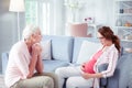 Loving grey-haired mother giving some advice to pregnant daughter