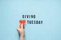 Giving Tuesday, Give, Help, Donation, Support, Volunteer concept with red heart in female hands and text Giving Tuesday Royalty Free Stock Photo