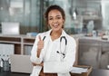 Giving you the all clear. Cropped portrait of an attractive young female doctor giving thumbs up while working in her Royalty Free Stock Photo