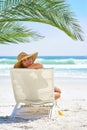 Giving you a sunny smile. Rearview portrait of a young woman relaxing at the beach.