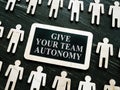 Giving your team autonomy quote and small figures. Royalty Free Stock Photo