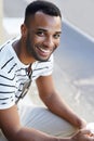 Givng you his brightest smile. A handsome casually dressed african american businessman sitting in the city while Royalty Free Stock Photo