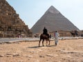 Giza, Cairo, Egypt - September 30, 2021: Pyramids of Giza, a complex of ancient monuments on the Giza plateau. Egyptians ride