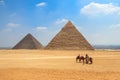 Horse carriage with tourists in front of the Pyramid of Khufu and the Pyramid of Khafre in Egypt Royalty Free Stock Photo