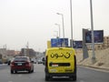 Noon online shopping delivery yellow van to deliver a package, Arabic Translation (Noon.com express for