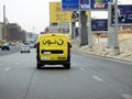 Noon online shopping delivery yellow van to deliver a package, Arabic Translation (Noon.com express for fast delivery