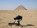 Giza, Egypt, January 26 2023: A Nikon digital DSLR camera on a tripod Photographing The red north pyramid of Dahshur of king