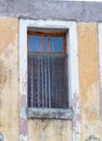 Window with Sheer Curtains in a Building with Chipped Gold Paint over Stucco