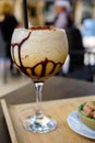 Glaass of iced frappuccino coffee with whipped cream, chocolate and ice cubes