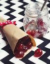Glace cherries in paper cone on chevron background