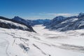 Glacial cracks and crevasses wind through a snowy basin in the alps