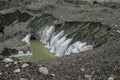 Glacier cracks covered with gray rocks, dirty ice