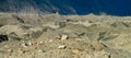 Glacier cracks and ice covered with gray morena stones