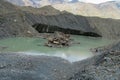 Glacier cracks and ice covered with gray morena stones