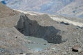 Glacier cracks and ice covered with gray morena stones