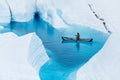 Glacier kayaking over ice cave and deep blue lake in the rain