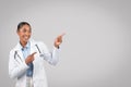 Glad adult african american lady doctor point fingers to copy space