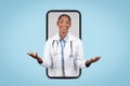 Glad adult african american woman doctor hold free space on hands on big phone screen