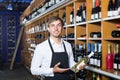 Glad adult seller man promoting bottle of wine