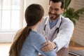 Glad attending physician telling woman patient about recovery of health
