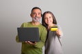 Glad caucasian senior man with laptop and woman with credit card recommend cashback