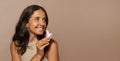 Glad caucasian senior woman make facial massage with quartz petal, look at copy space