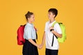 Glad caucasian teenage girl holding hand boy pupil, enjoy friendship