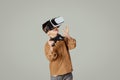 Glad caucasian 6 years old little kid in vr glasses with joystick look at empty space