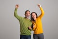 Glad cheerful old european couple celebrating victory, making success gesture with hands