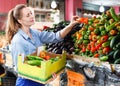 Woman is choosing vagetables with box in the market.