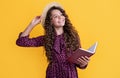 glad child with frizz hair read book on yellow background