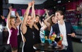 Colleagues dancing on corporate party with cocktails in hands