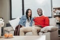 Glad couple sitting and hugging on sofa inside Royalty Free Stock Photo